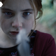 A small girl studies a feather in a scene from horror movie Martyrs Lane.